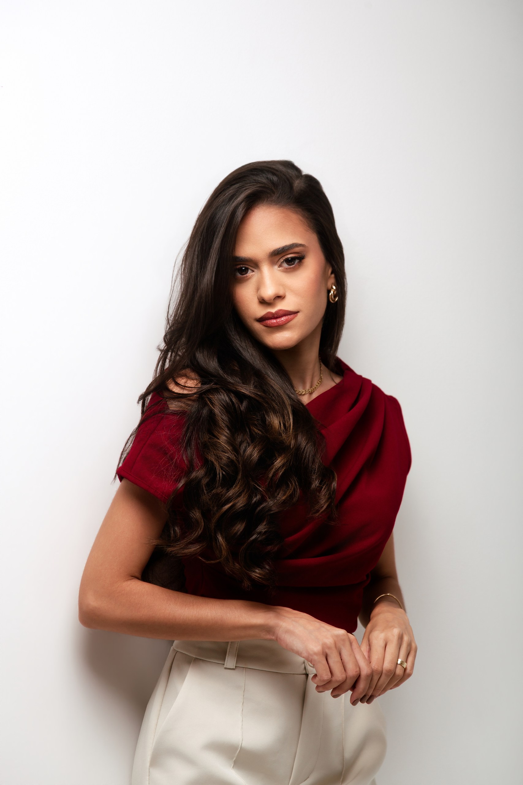 Dra. Natália Magalhães, médica, de blusa vinho, olhando para a câmera